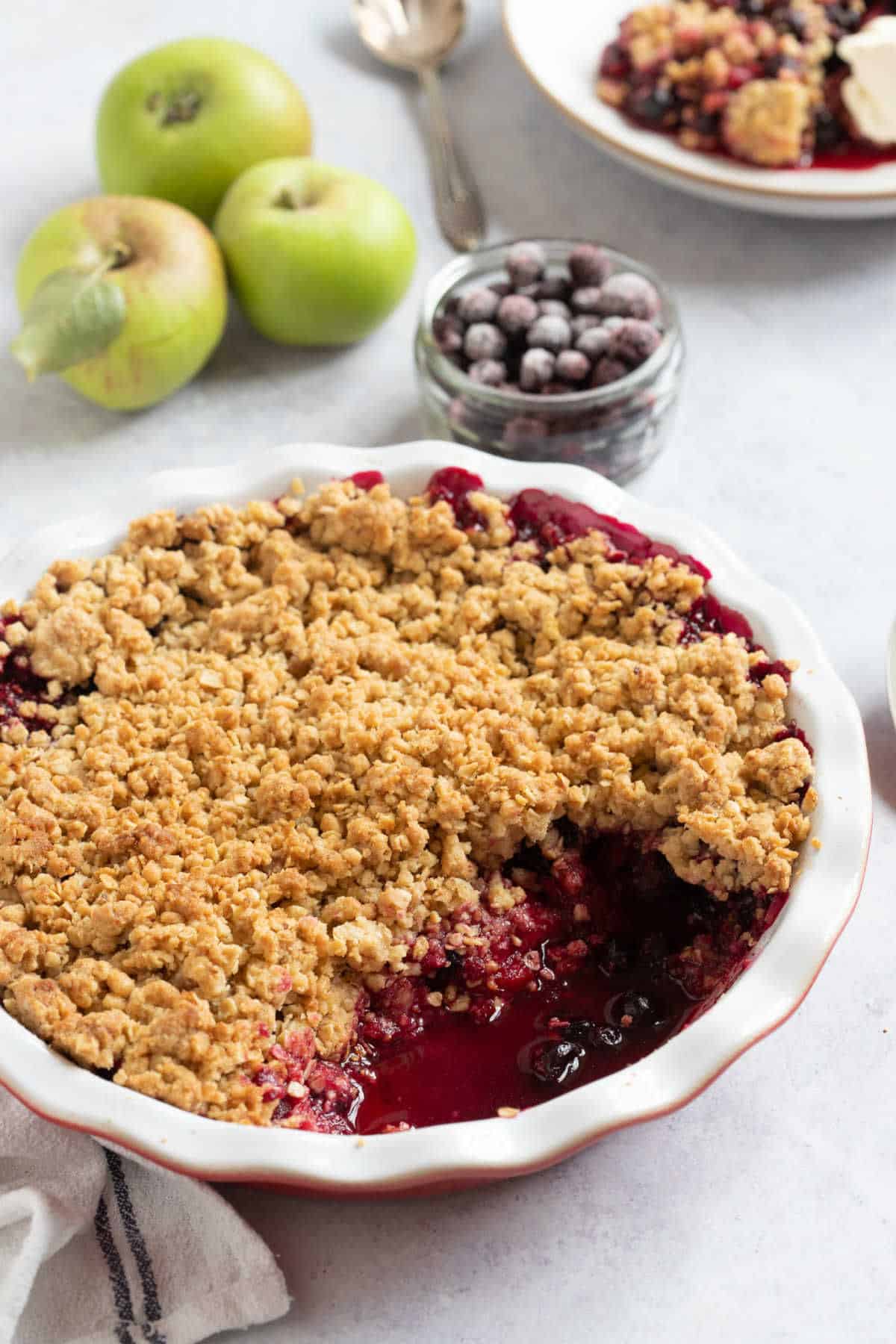 Blackcurrant crumble in a red pie dish.