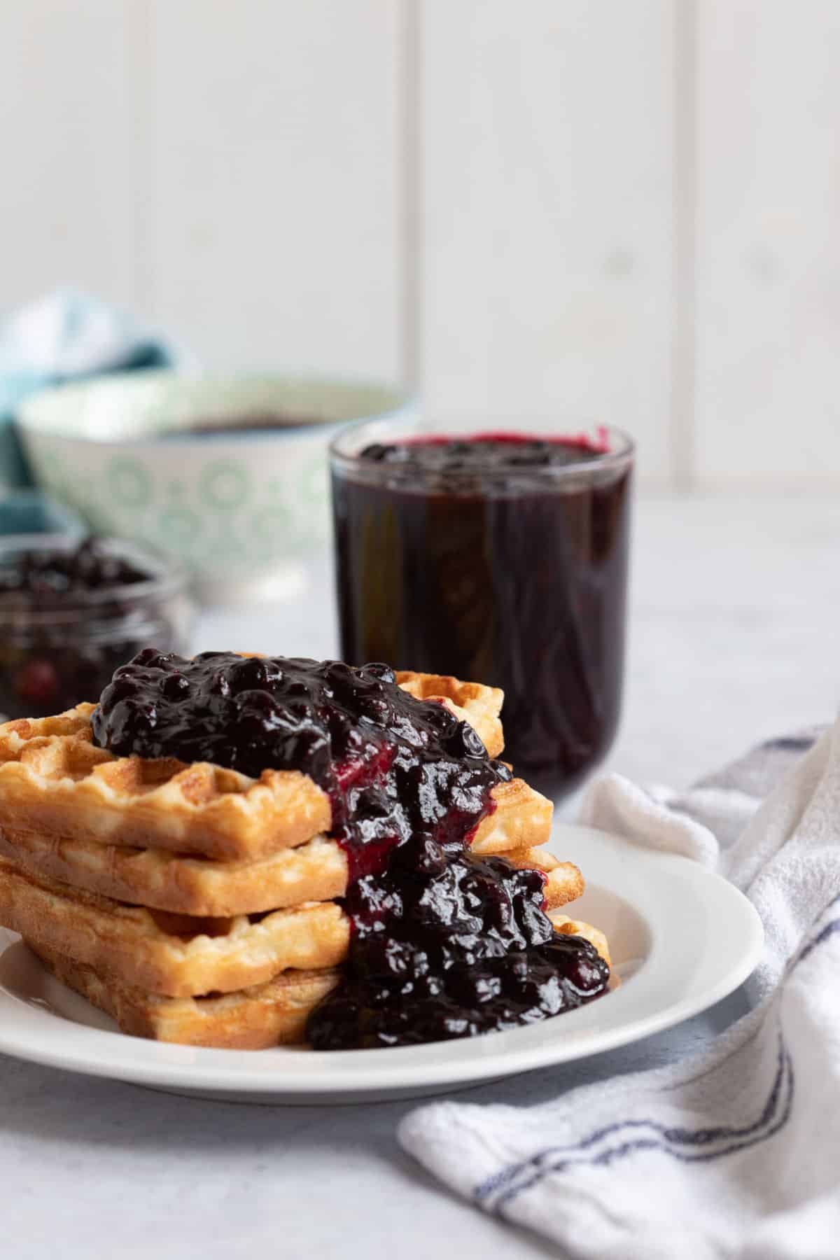 Blackcurrant compote on a stack of waffles.