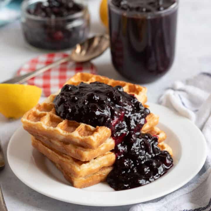 Blackcurrant compote spooned over waffles.