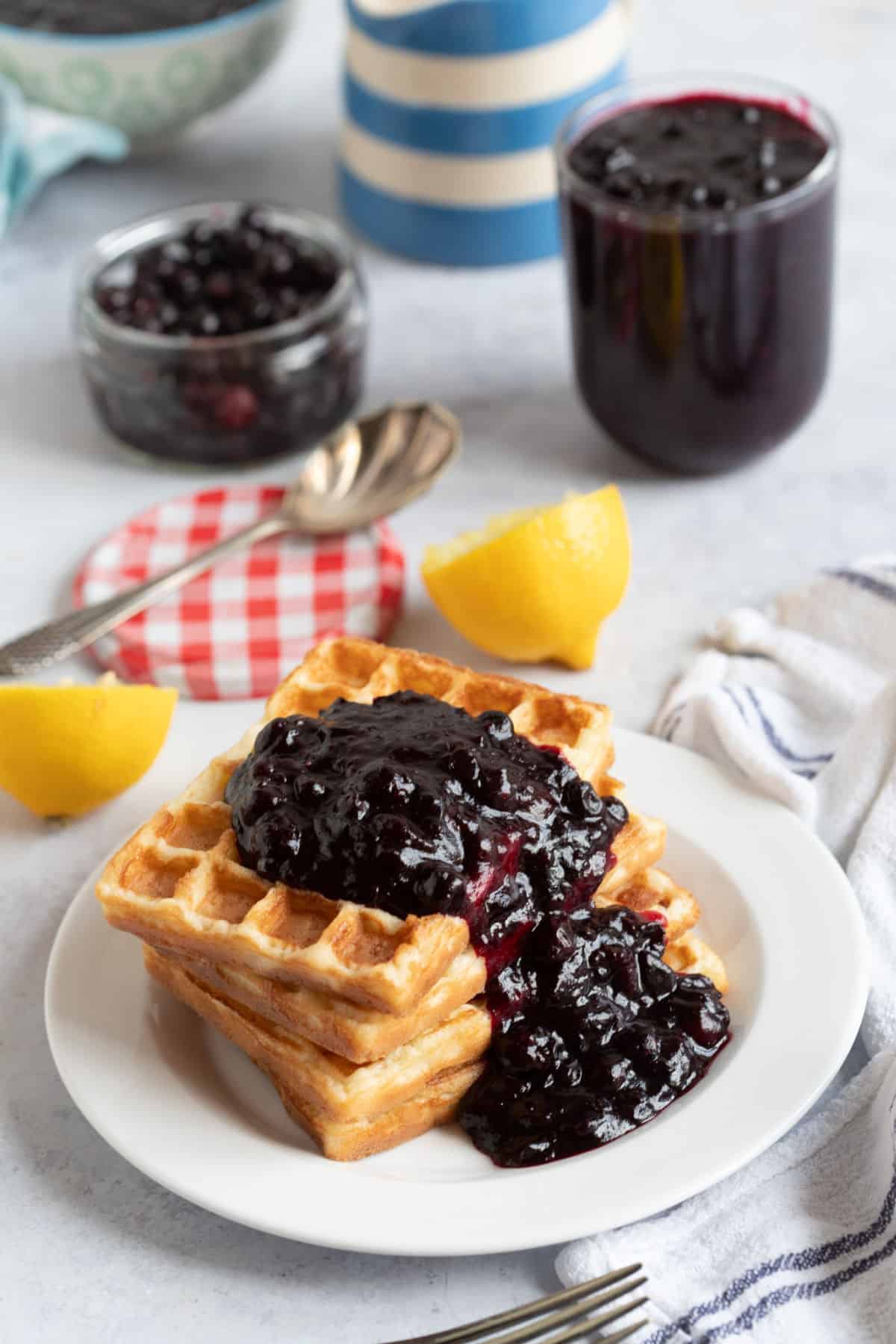 Blackcurrant compote on a stack of waffles.