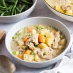 Chicken and vegetable stew in a grey bowl.