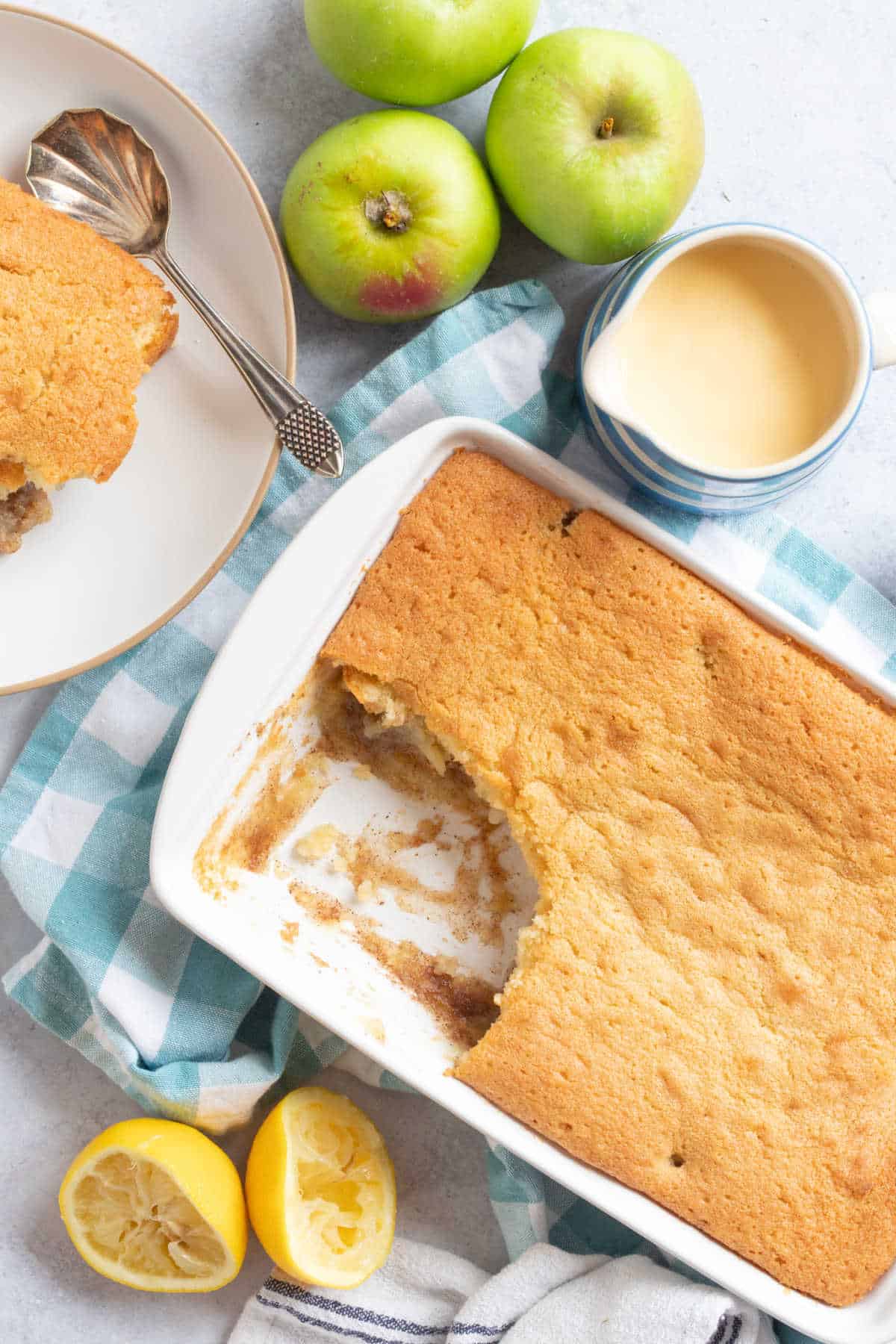 Apple sponge pudding with a jug of custard.