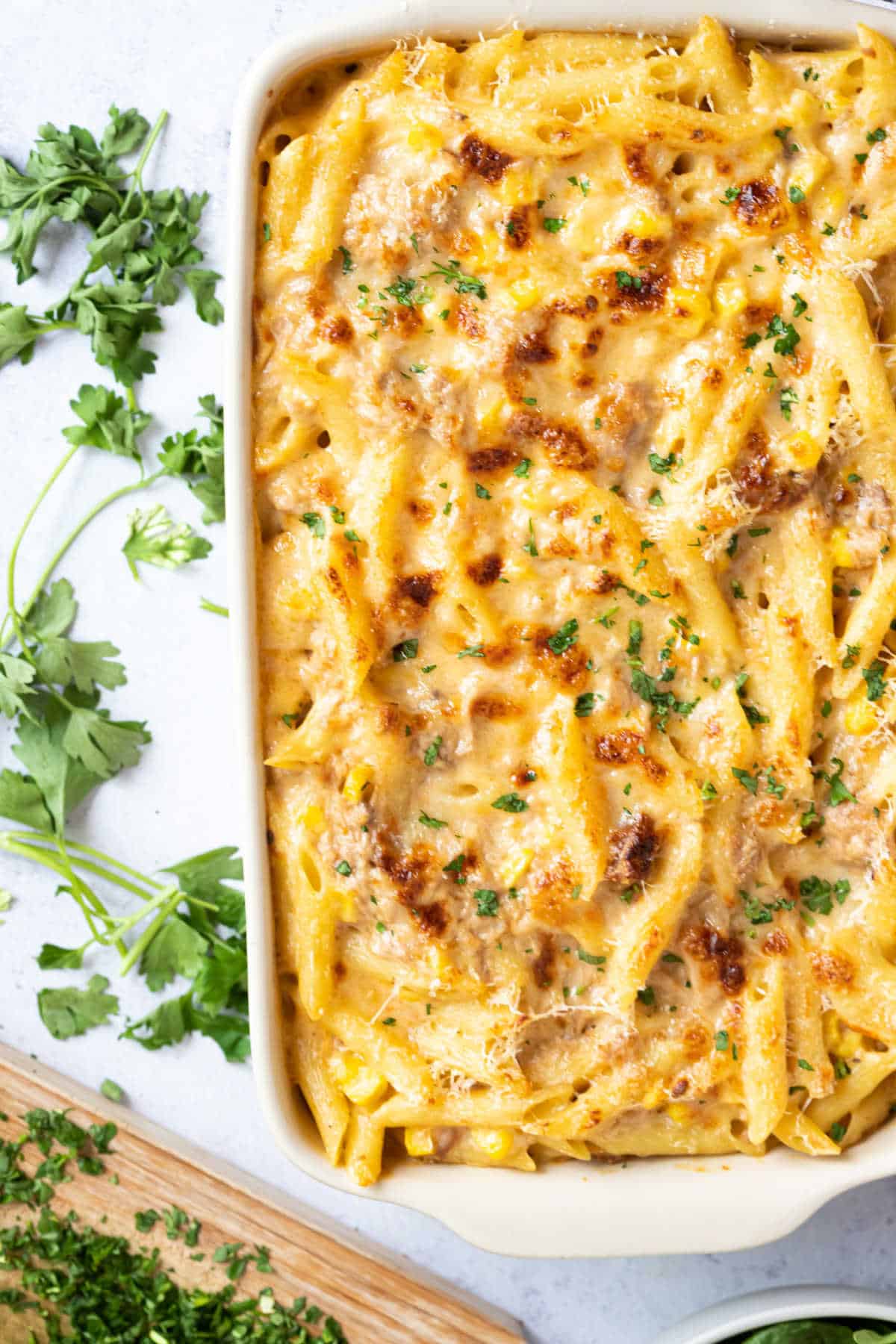 Tuna and sweetcorn pasta bake in a white baking dish.