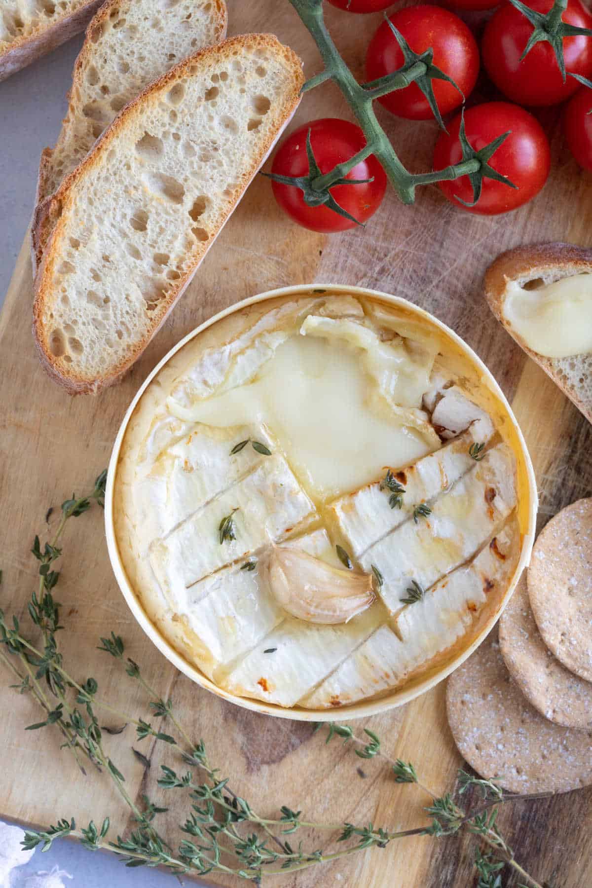 A baked camembert with slices of air fried baguette.