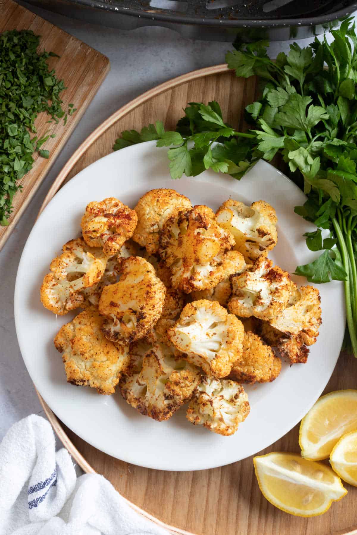 Air fried cauliflower florets on a white plate.