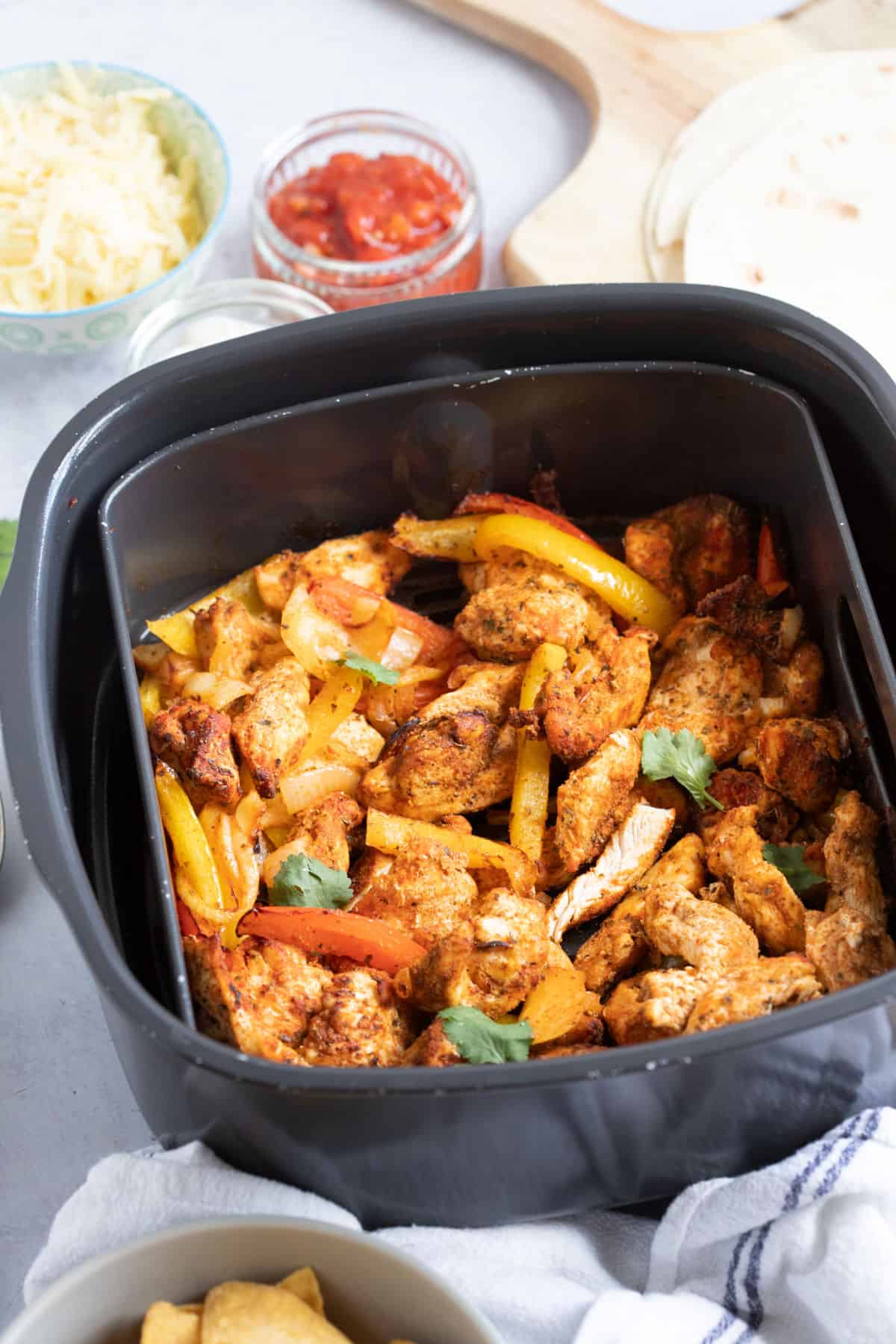 Chicken fajitas in n air fryer basket.