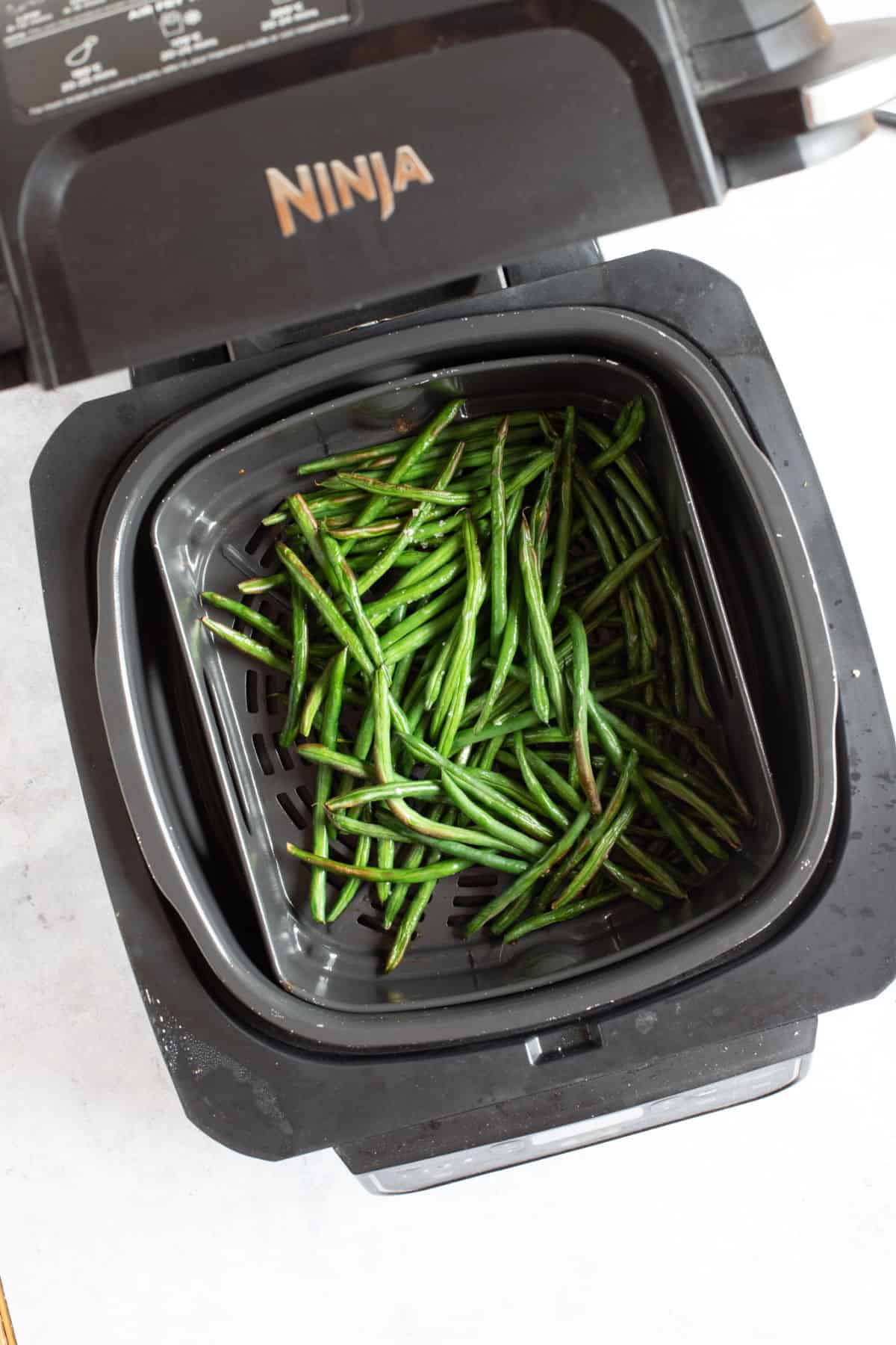 Green beans in a Ninja Foodi air fryer.