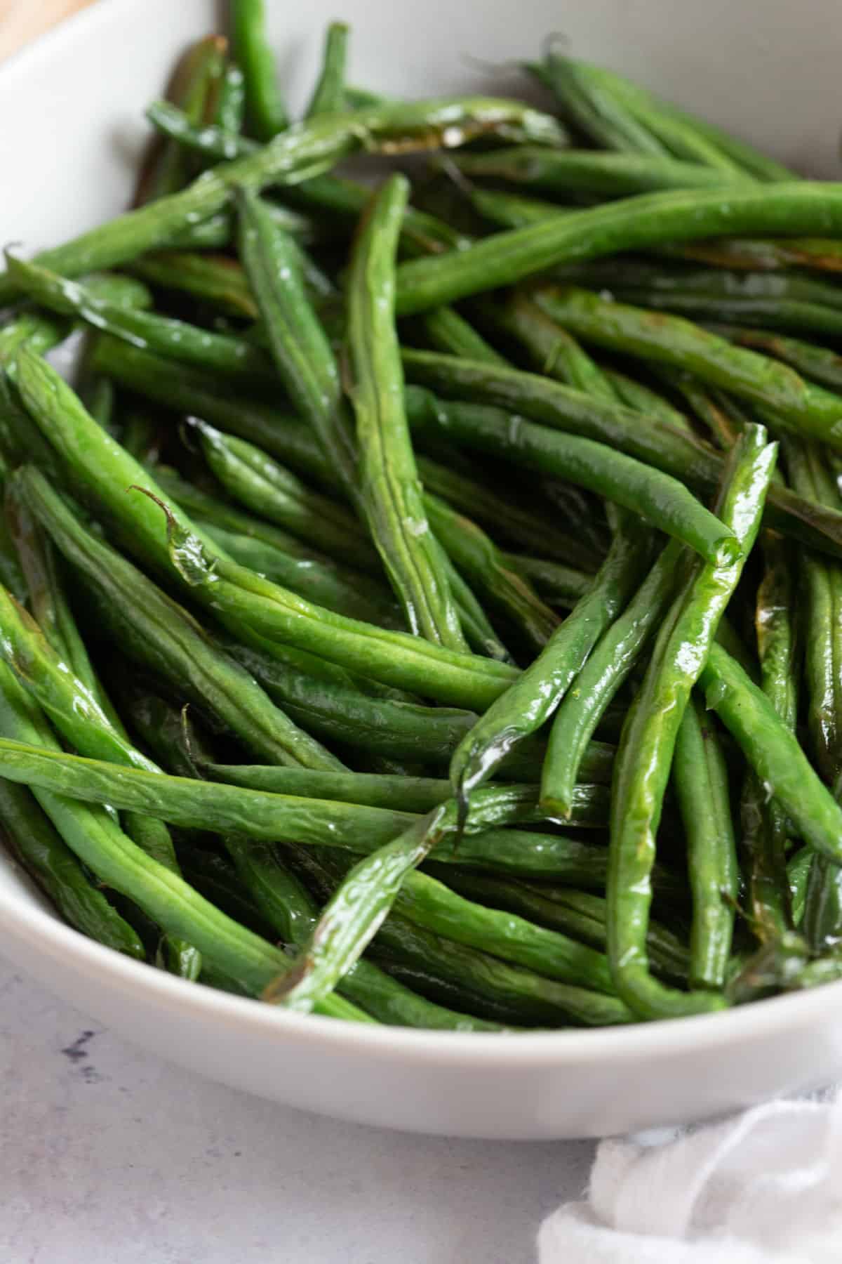 Crispy air fried green beans in a grey bowl.