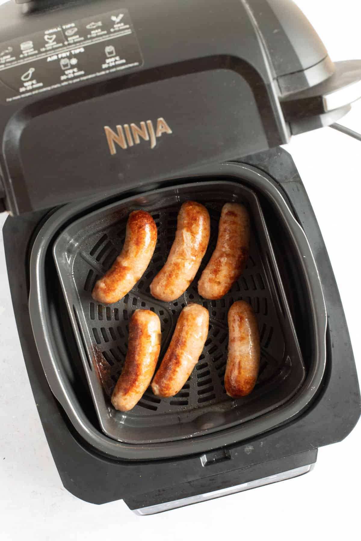 Pork sausages in an air fryer.