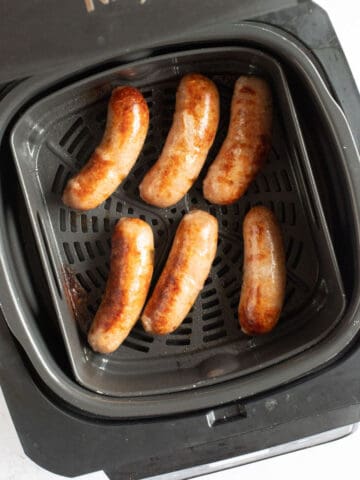 Sausages in Ninja Foodi air fryer basket.
