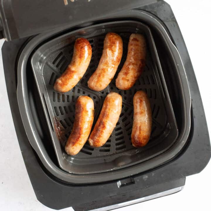 Sausages in Ninja Foodi air fryer basket.