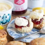 Air fryer scone on a blue plate with jam and clotted cream.