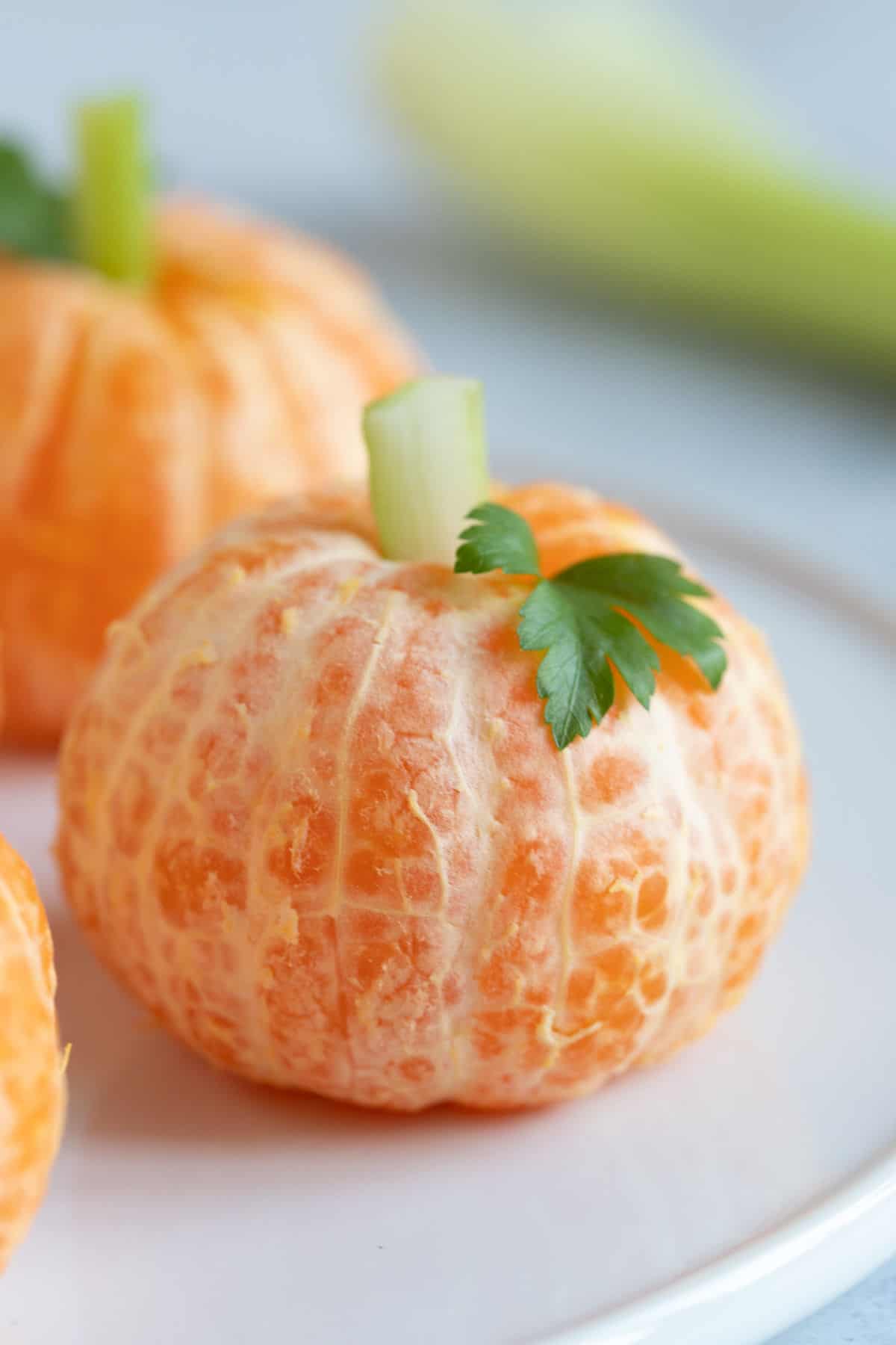 A Halloween clementine pumpkin on a plate.