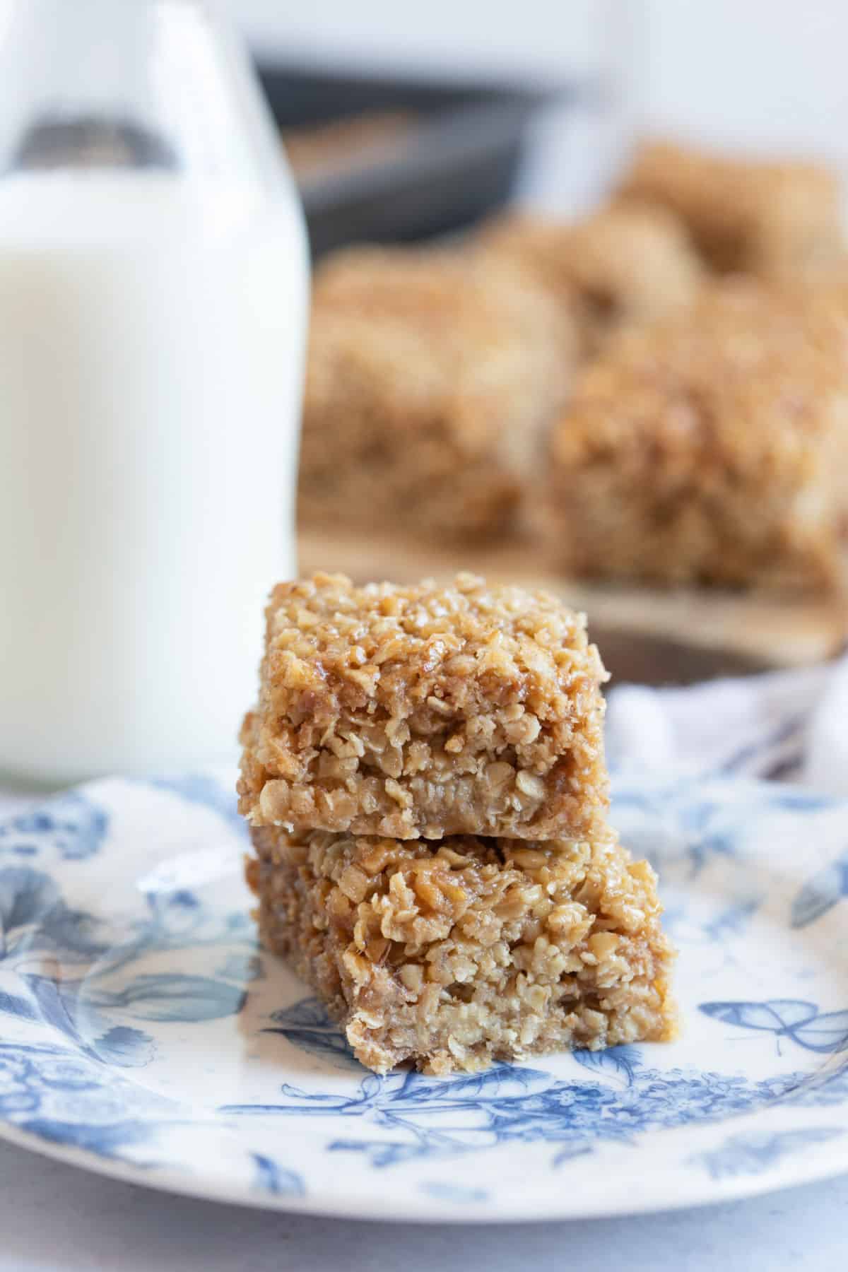 Flapjacks on a plate with a glass of milk.