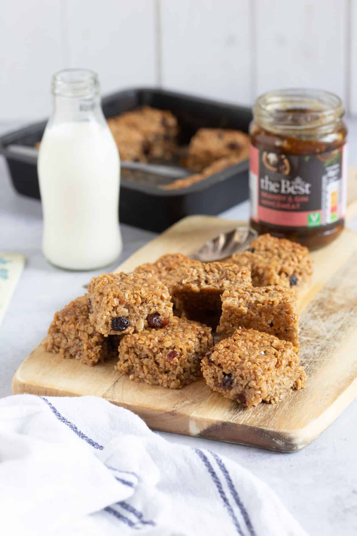 Mincemeat flapjacks on a wooden board with a glass of milk.