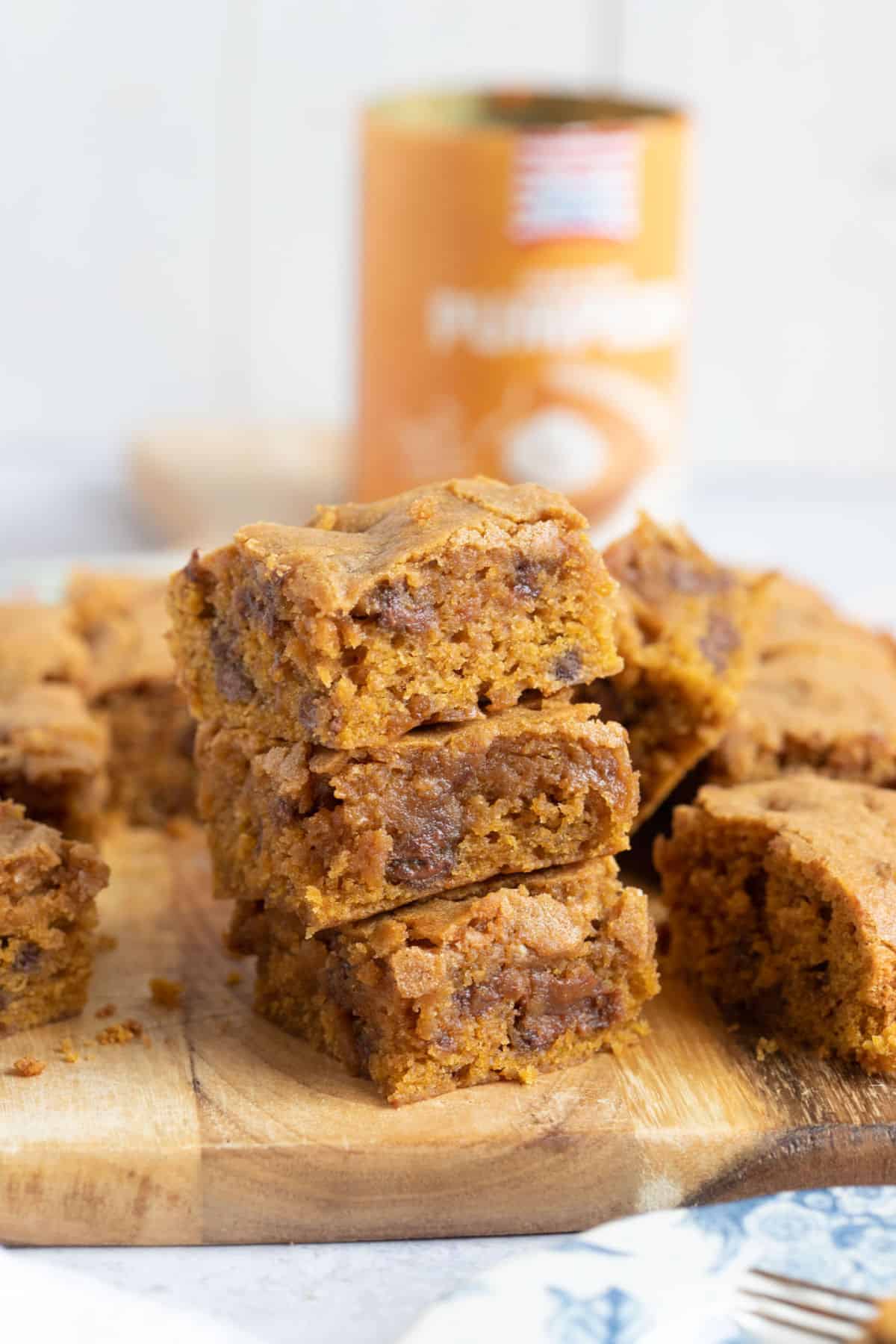 A stack of pumpkin blondies on a wooden board.