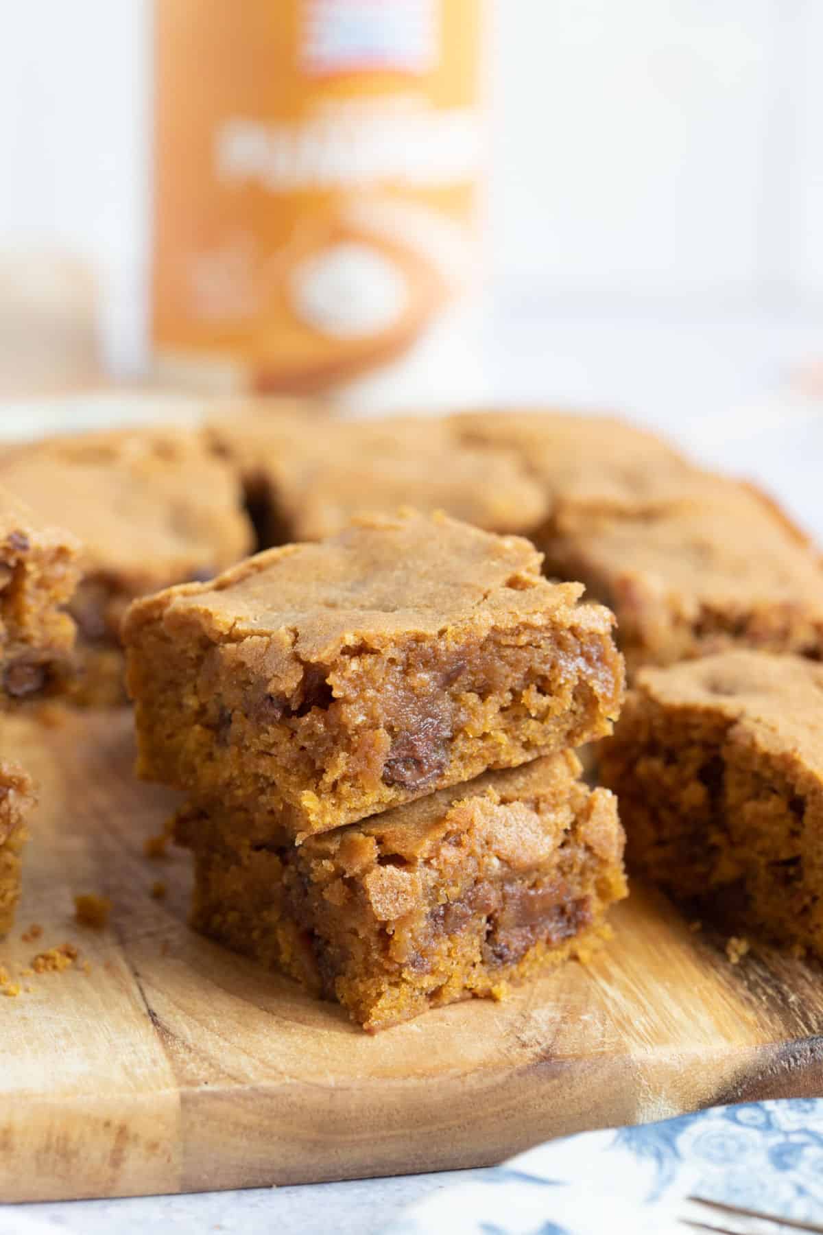 Chewy pumpkin blondies on a wooden board.