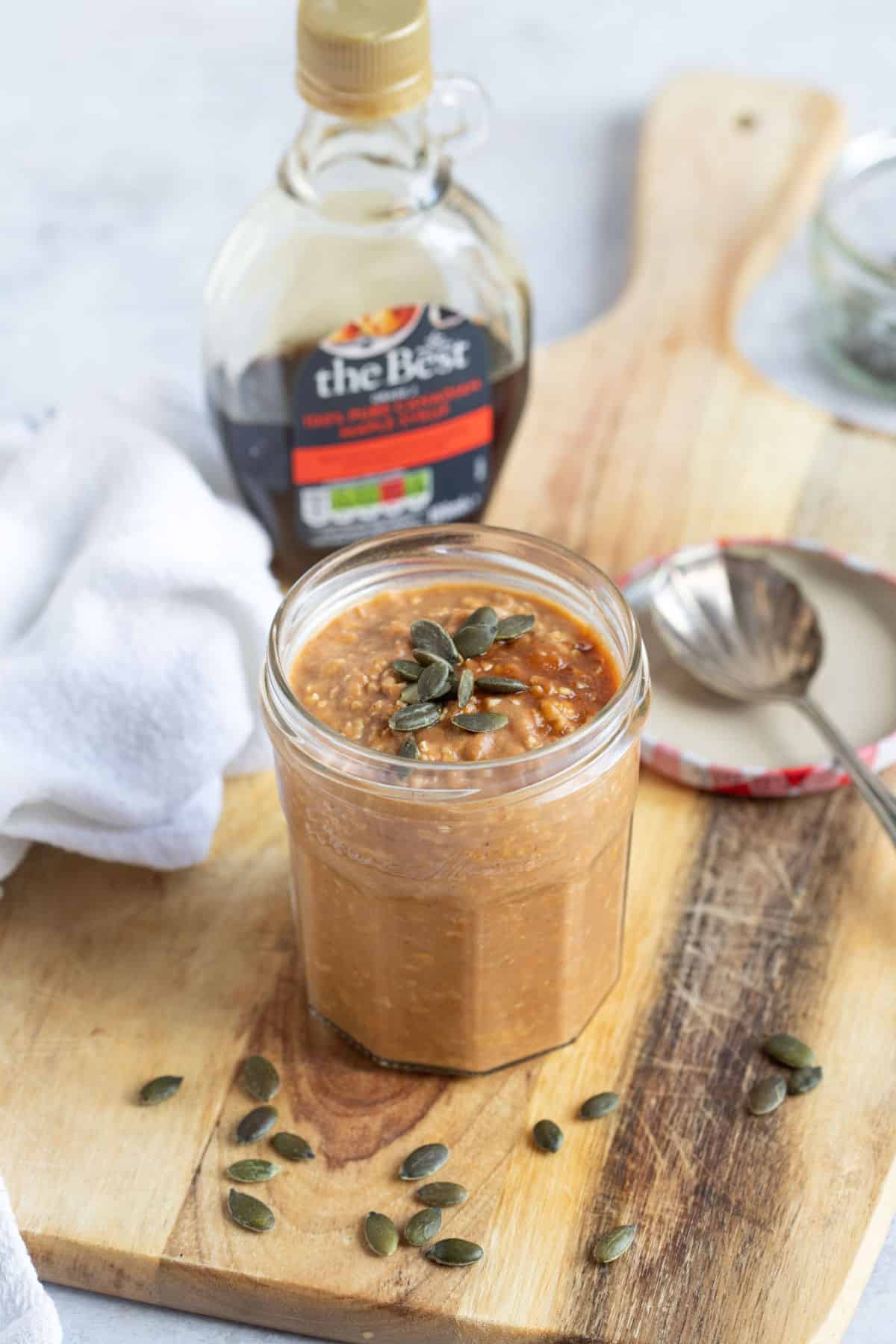 A jar of overnight oats with pumpkin seeds.