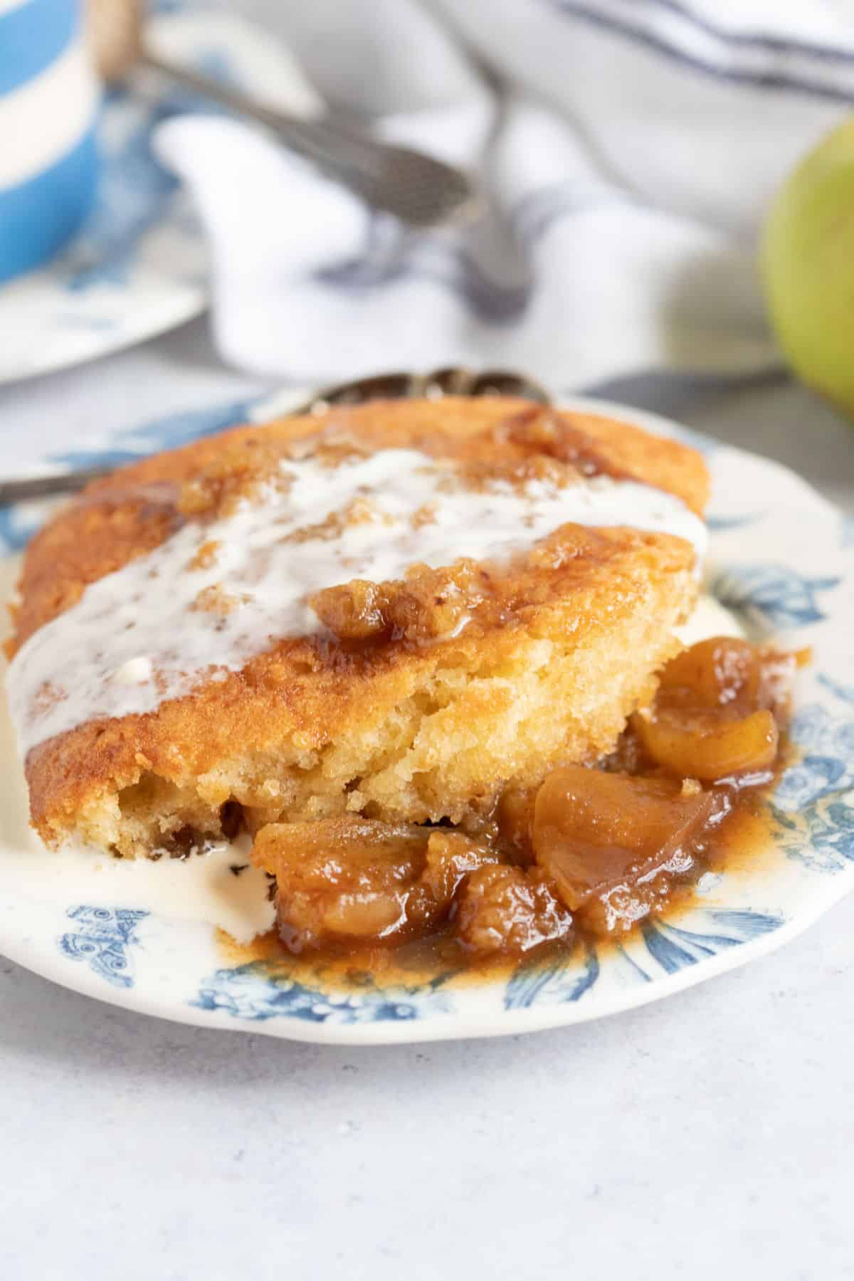 A portion of sticky toffee apple pudding with cream.