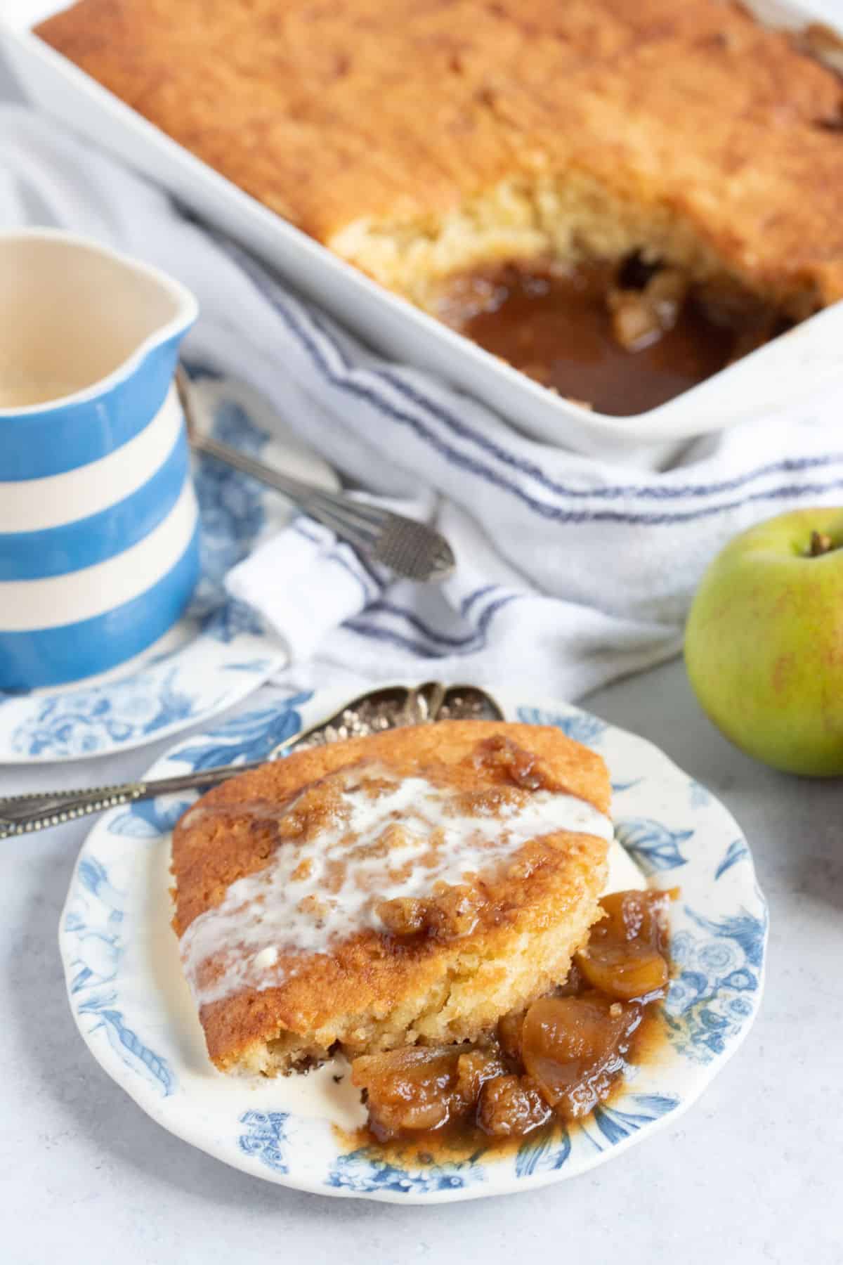 A portion of sticky toffee apple pudding on a blue plate.