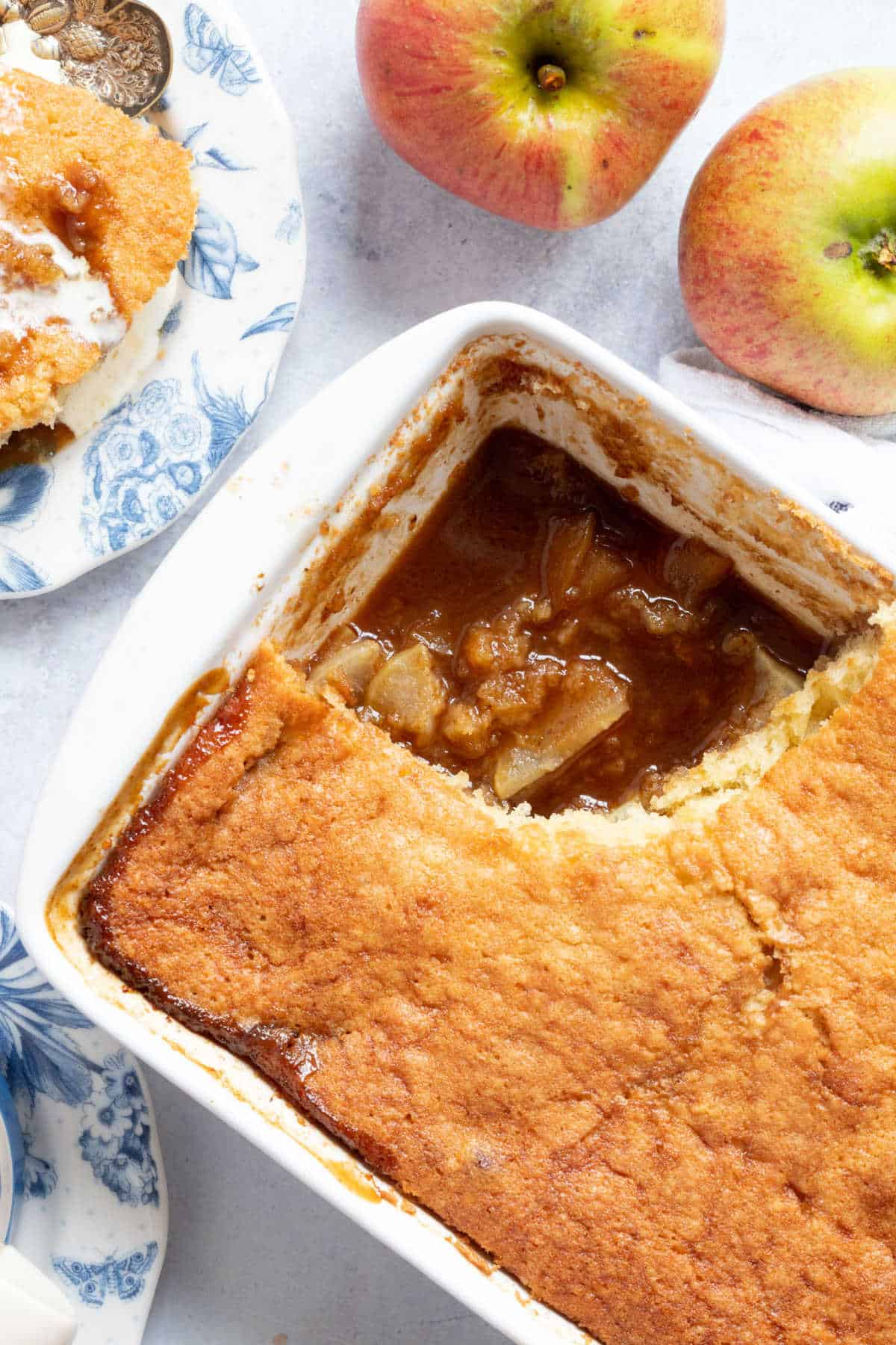 Sticky toffee apple pudding in a white baking dish.