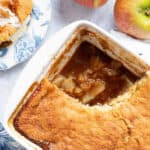 Sticky toffee apple pudding in a white pie dish.