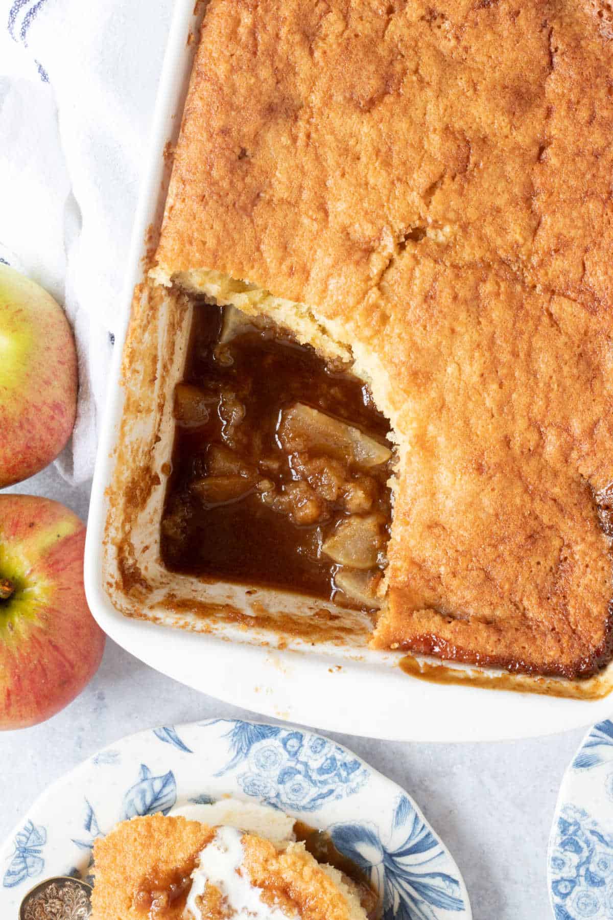 Sticky toffee apple pudding in a white baking dish.