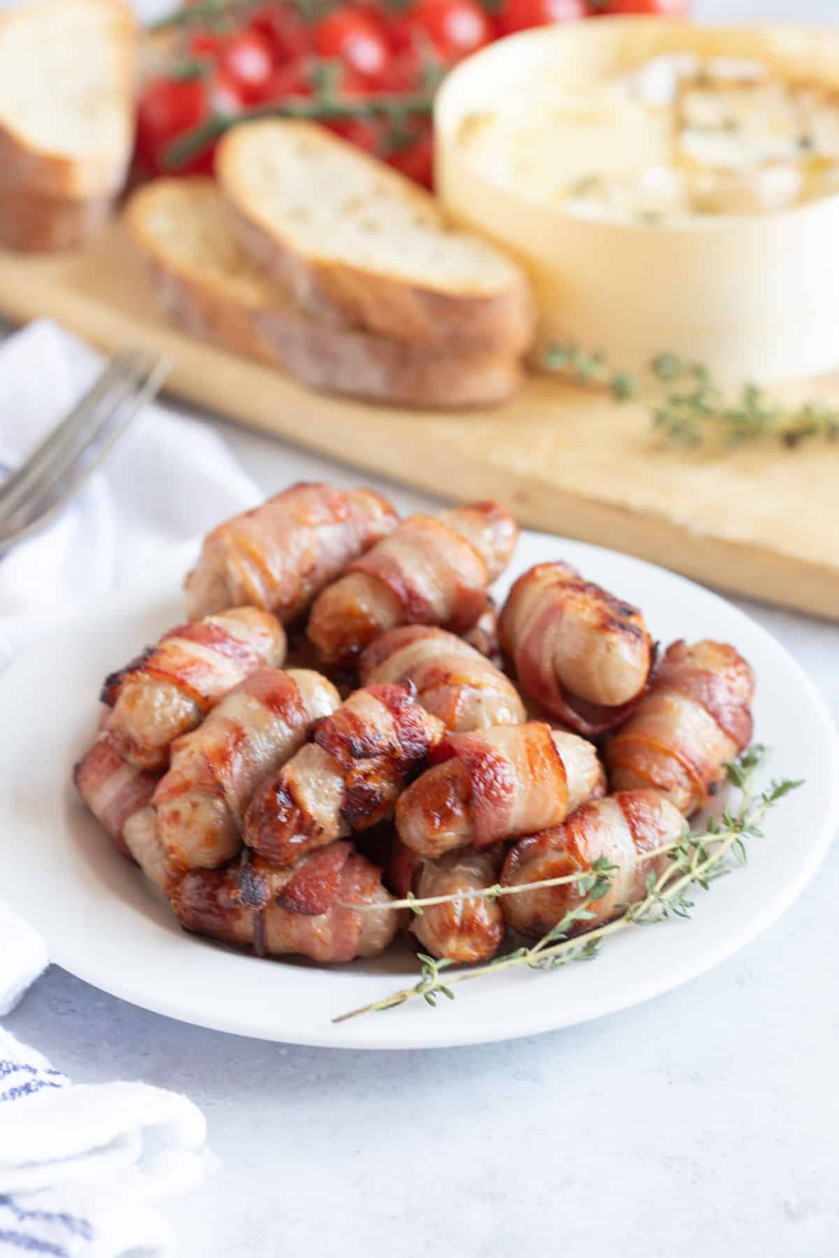 Air fried pigs in blankets on a white plate.