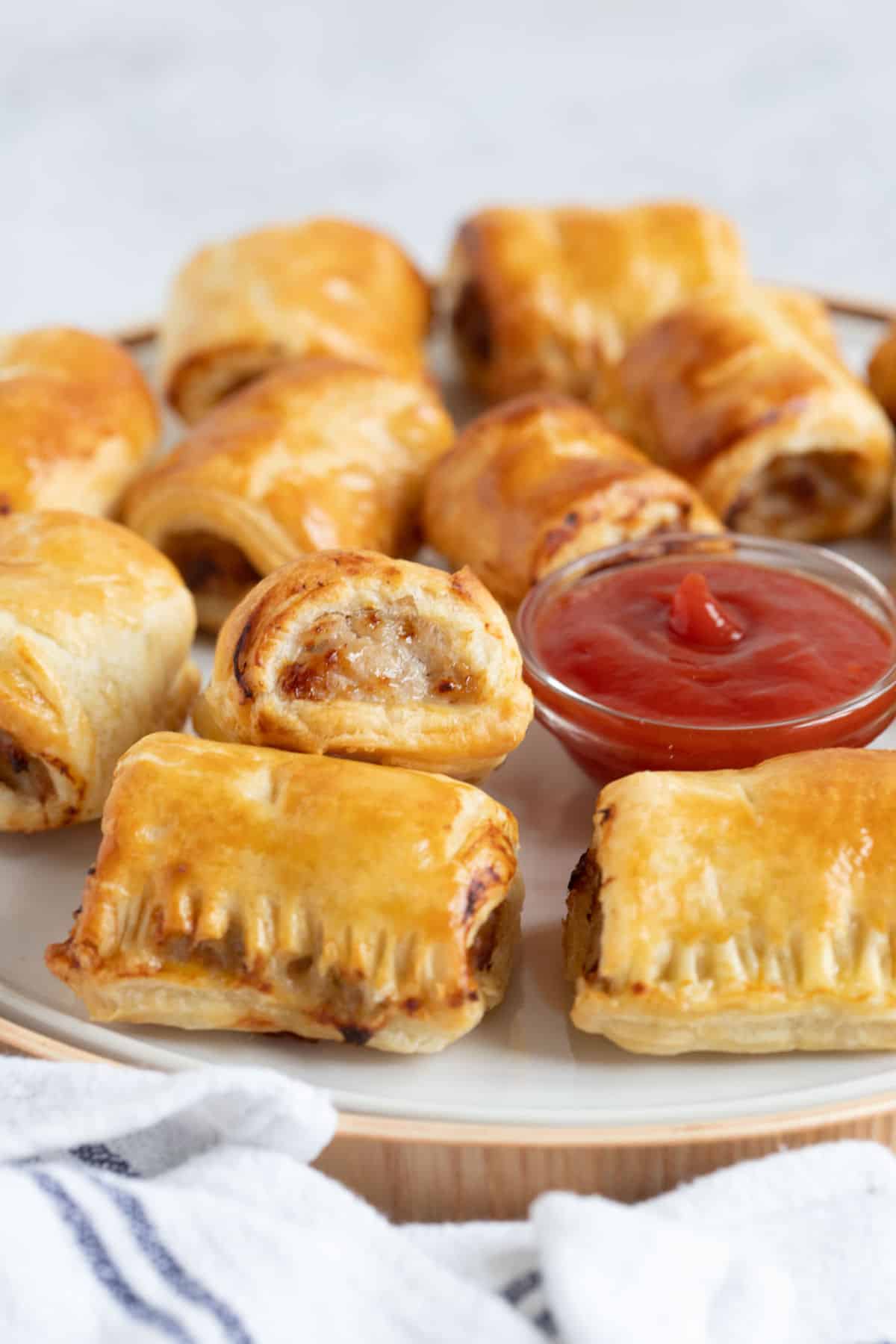 Mini sausage rolls on a round plate.