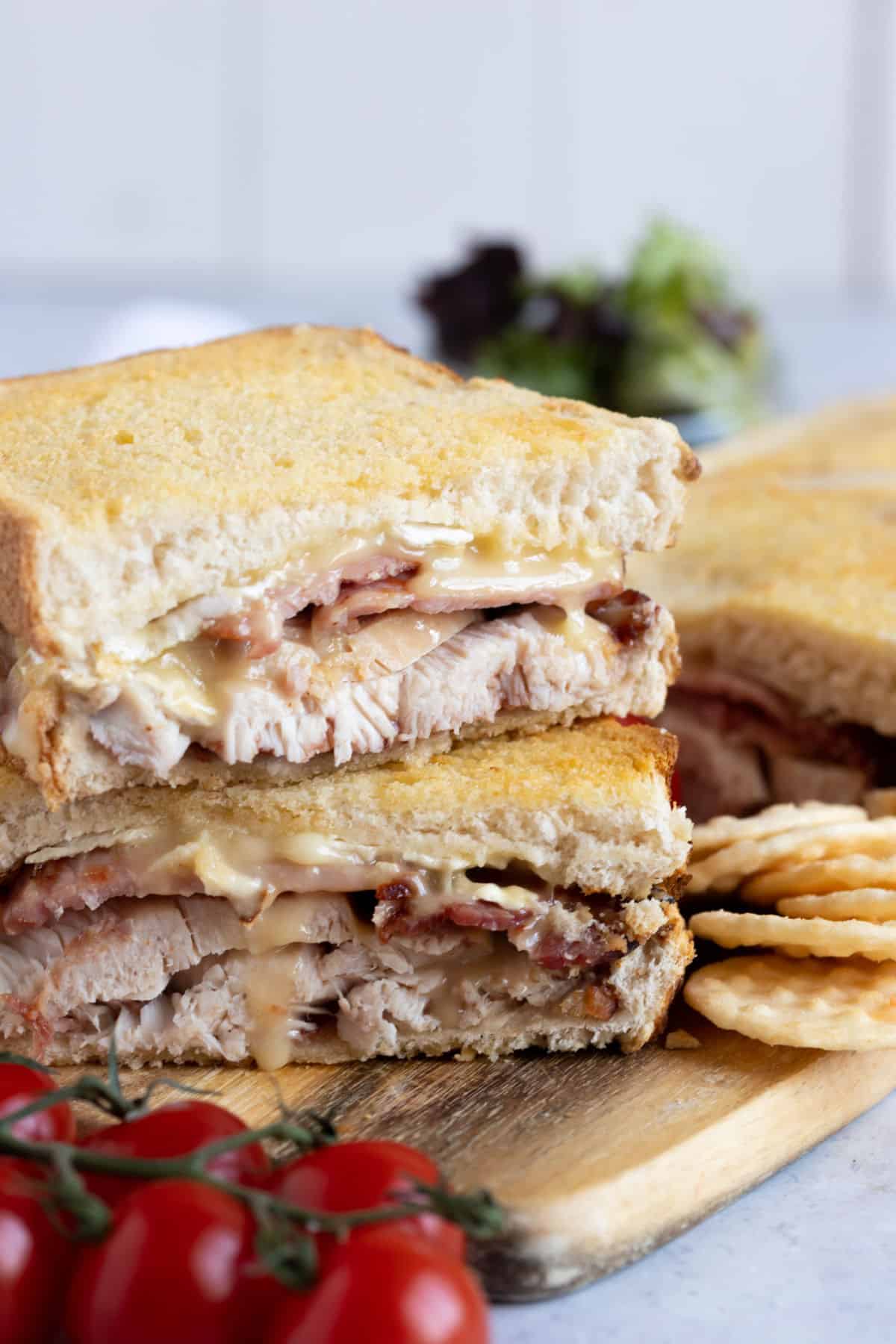 Air fryer turkey, bacon, and brie toastie on a wooden board.