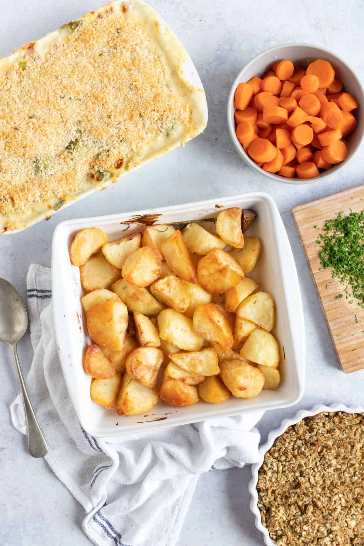 Potatoes in a white dish, with carrots and stuffing.