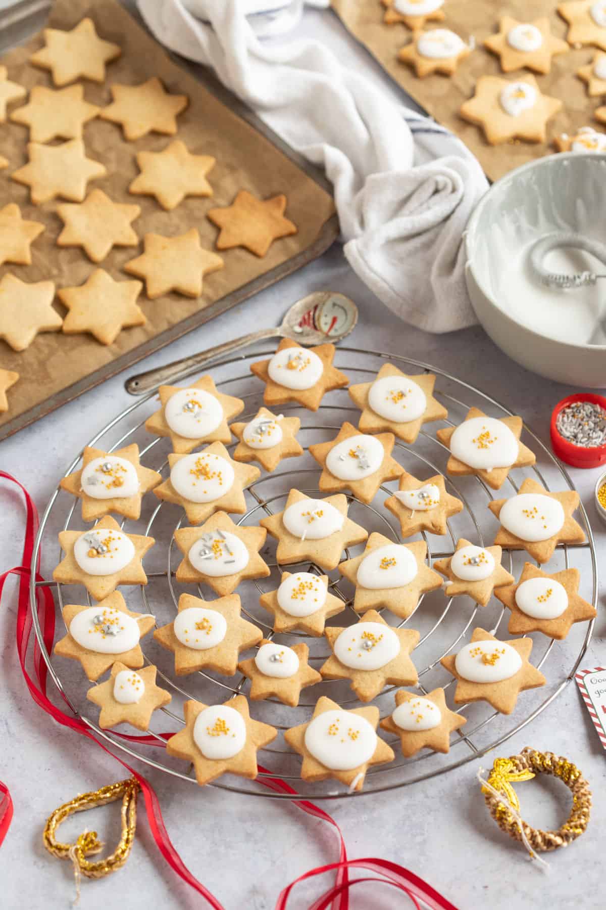 Christmas star biscuits on wire racks and baking trays.