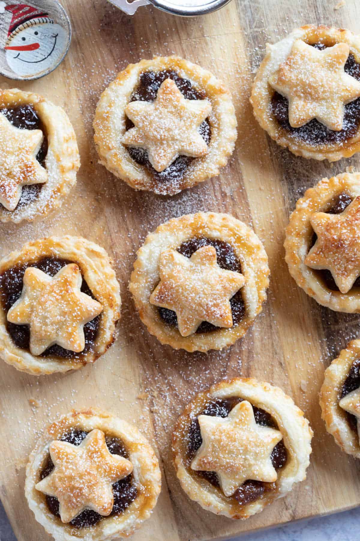 Puff pastry mince pies on a wooden board.