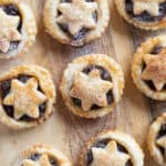 Puff pastry mince pies on a wooden board.