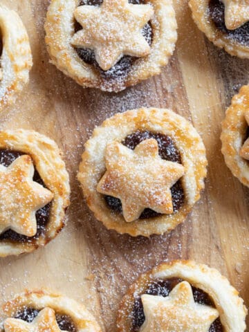 Puff pastry mince pies on a wooden board.