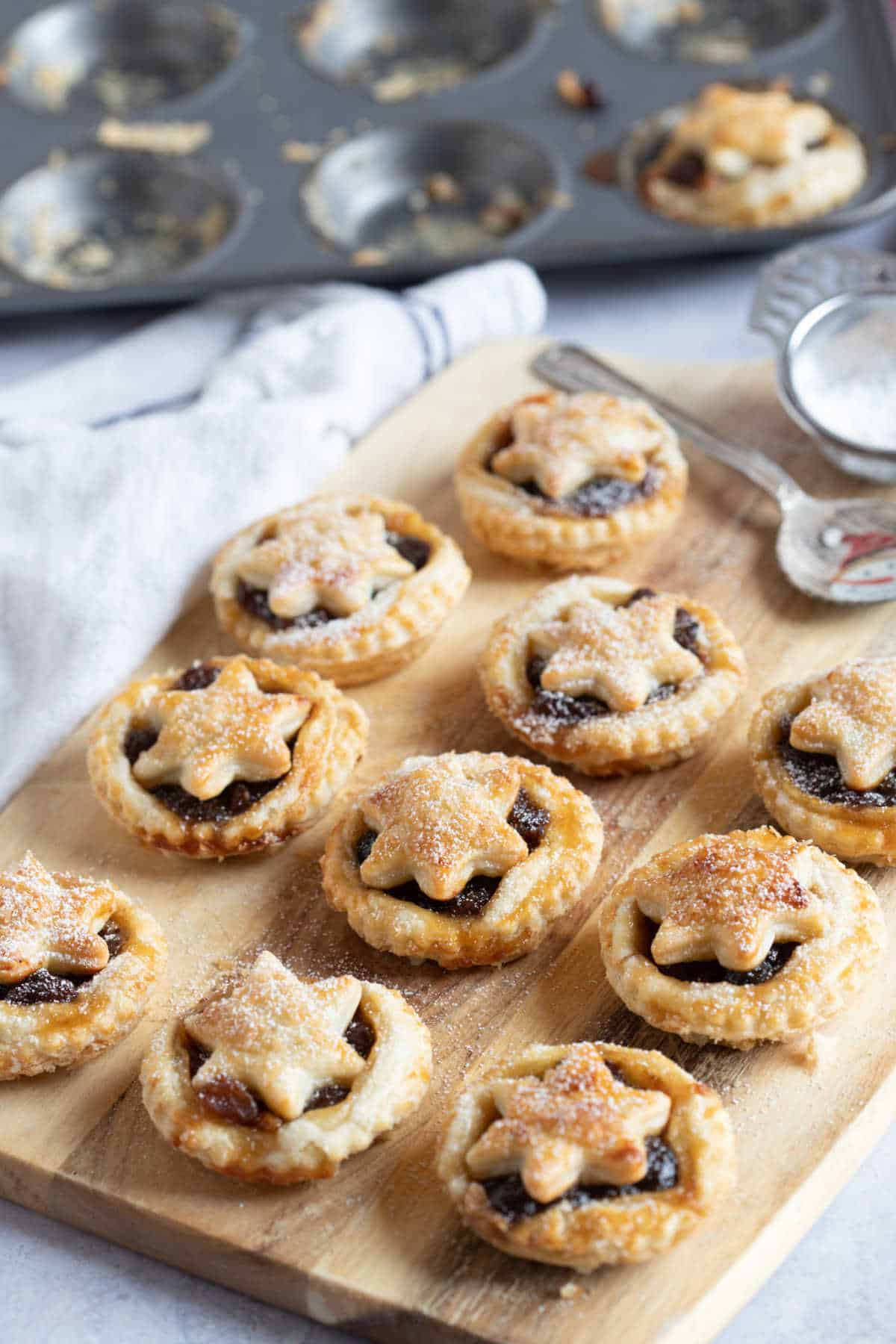 Puff pastry mince pies on a wooden board.