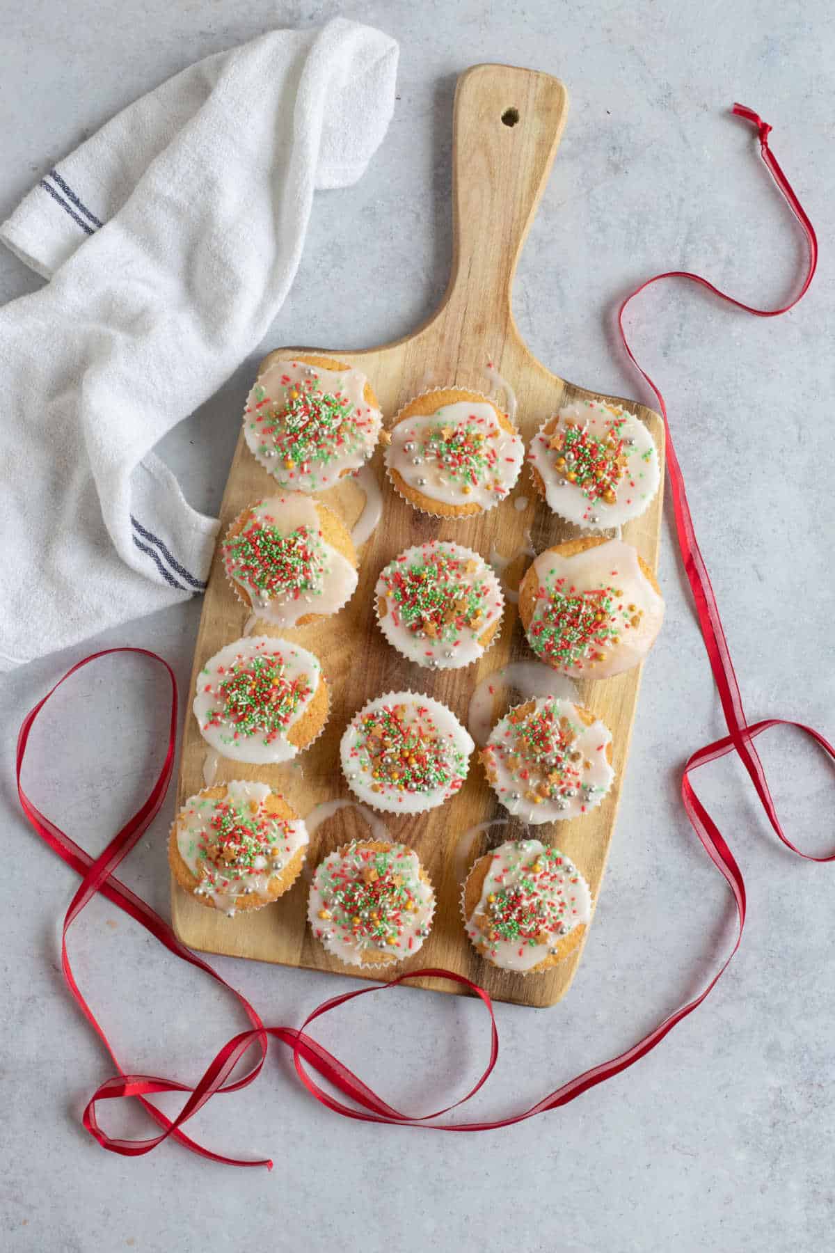 Fairy cakes with Christmas sprinkles with red ribbon.