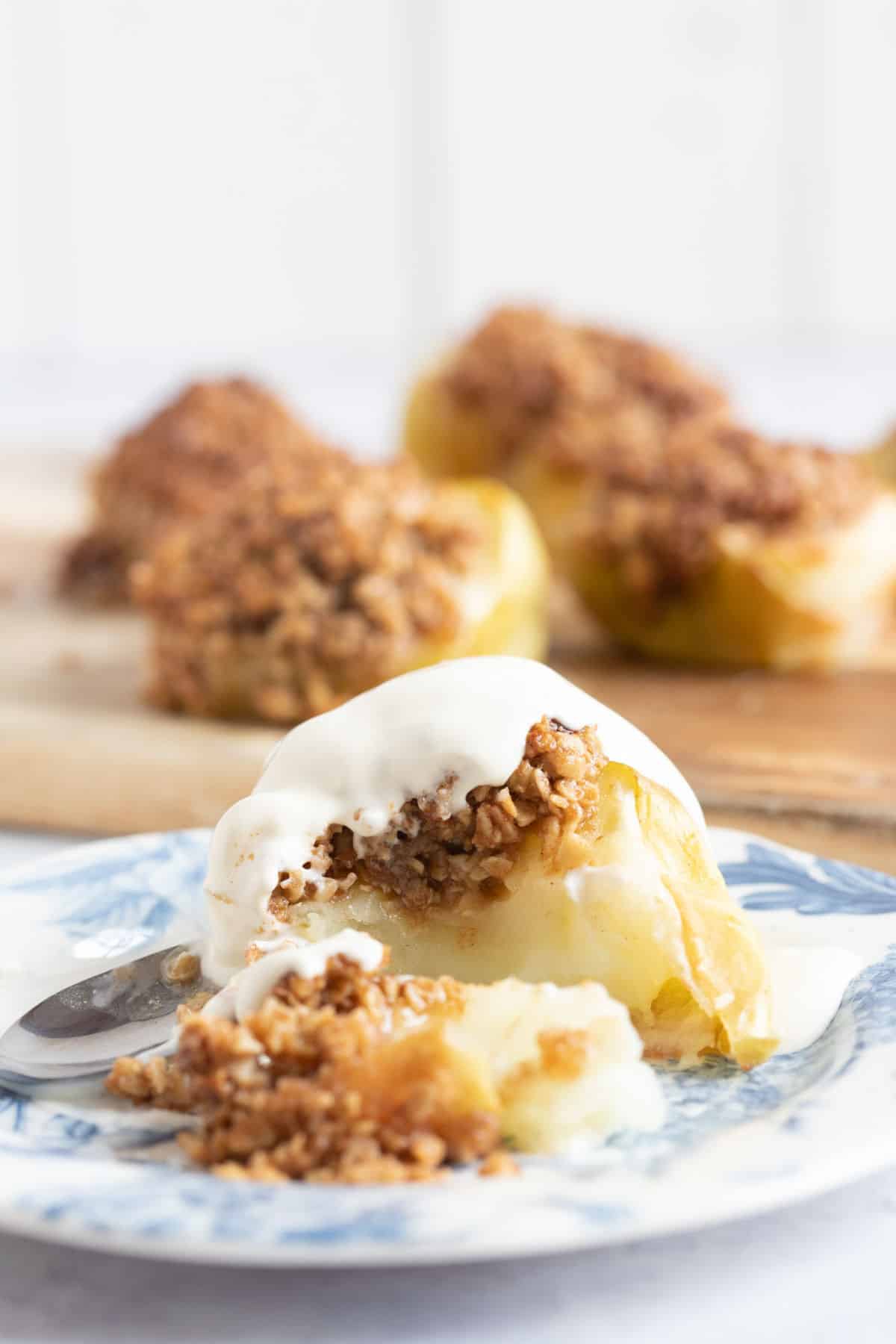 Air fryer baked apple on a plate with cream.