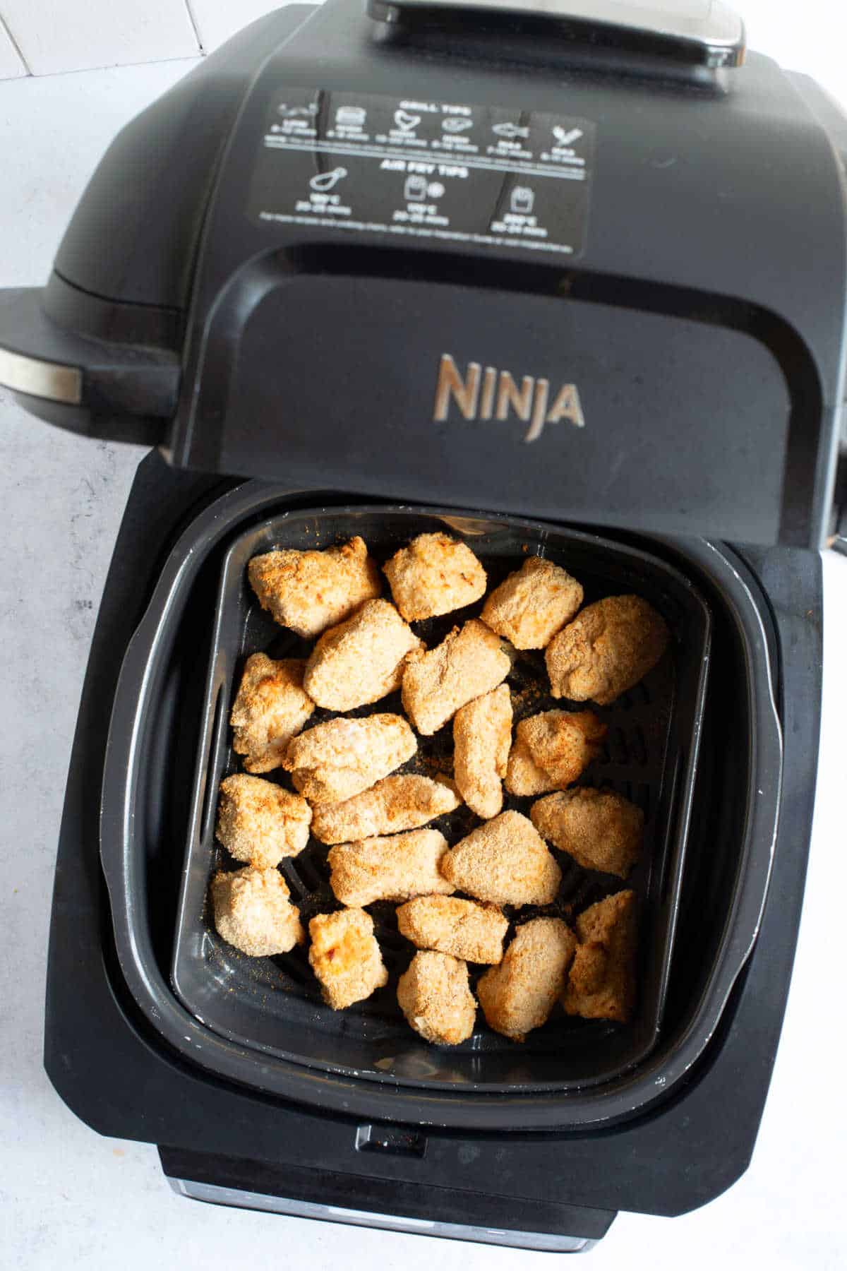 Homemade chicken nuggets in a Ninja Foodi air fryer.