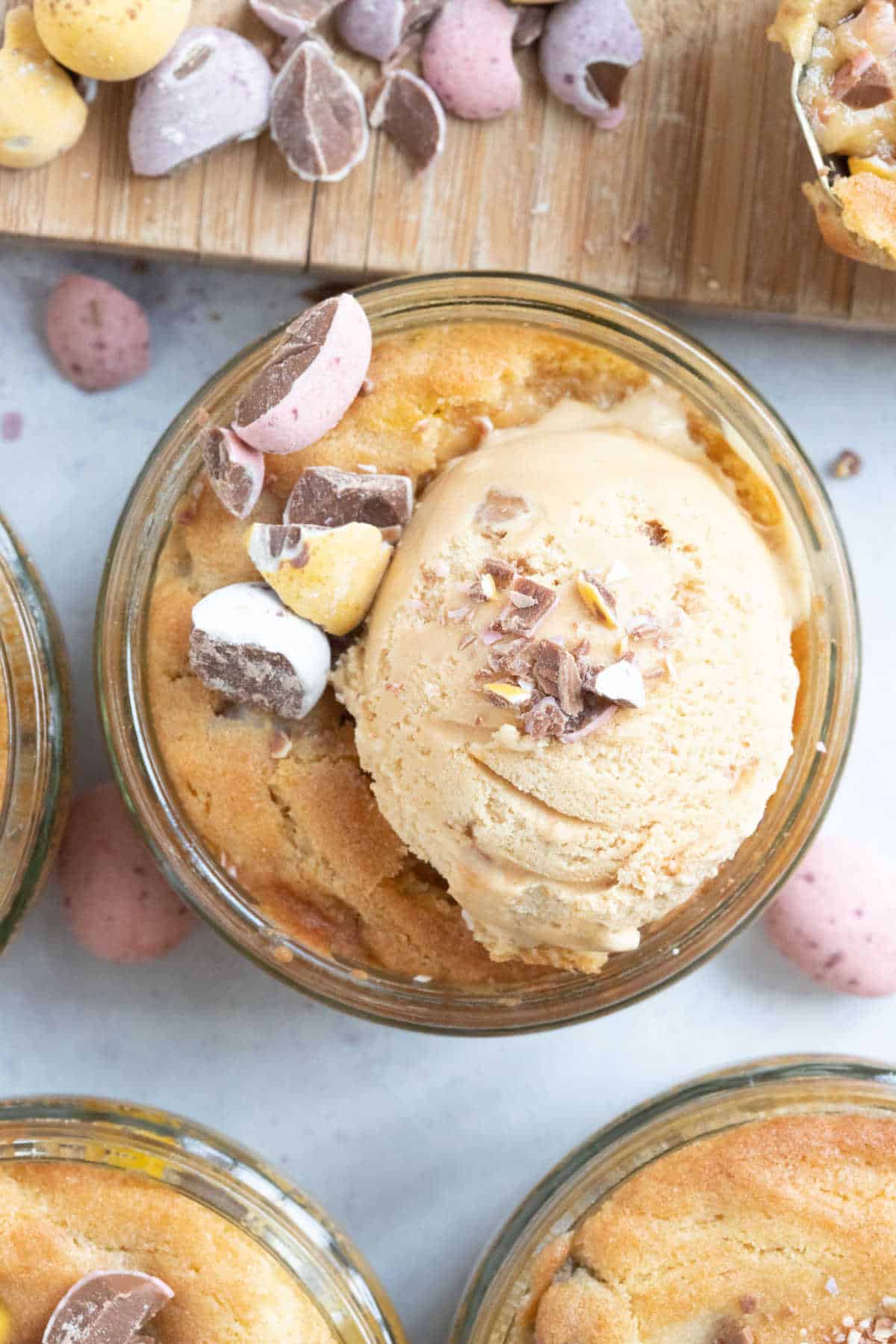 Mini egg cookie dough dessert pot with a scoop of ice cream on top.
