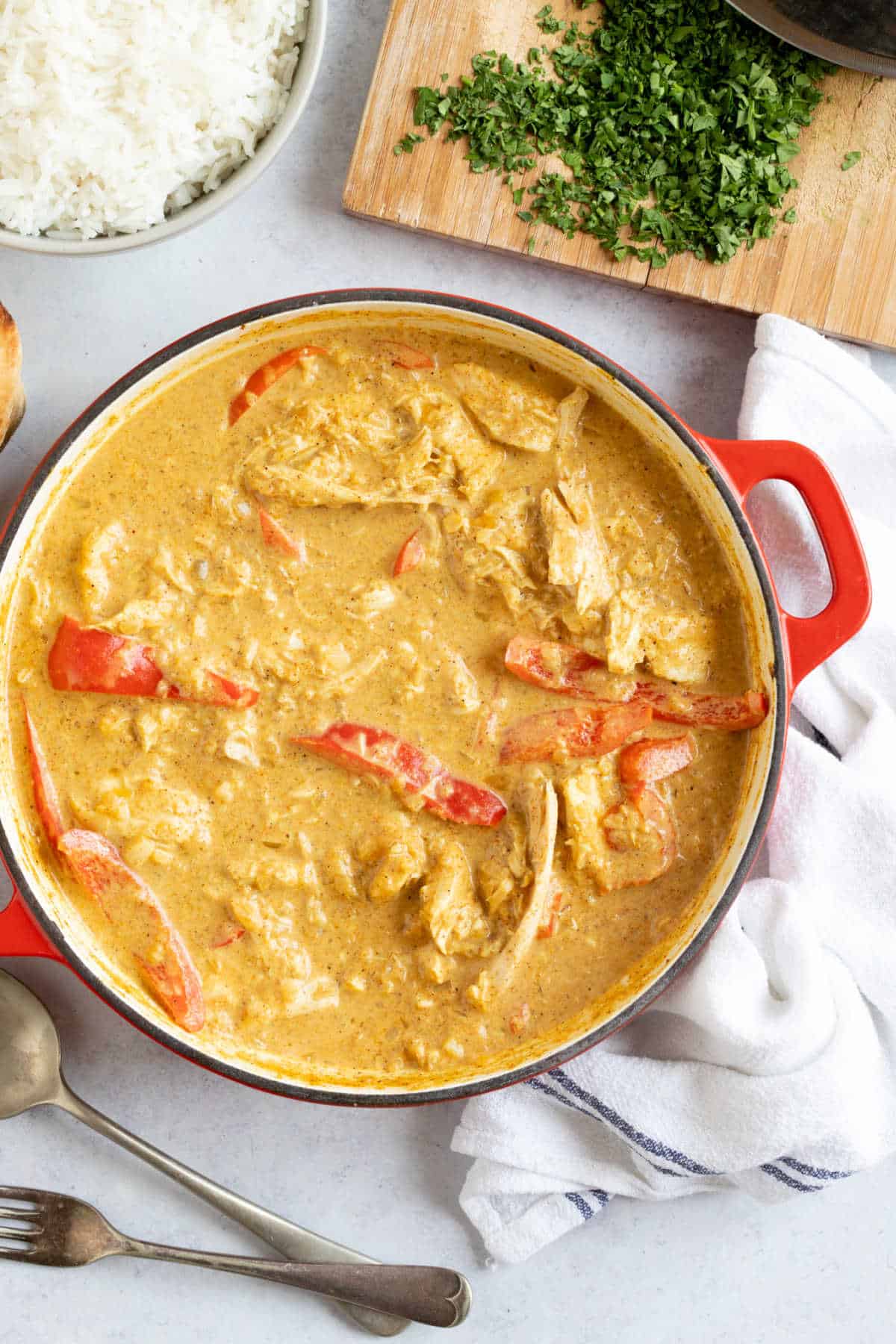 Leftover chicken and red pepper curry in a red pan.