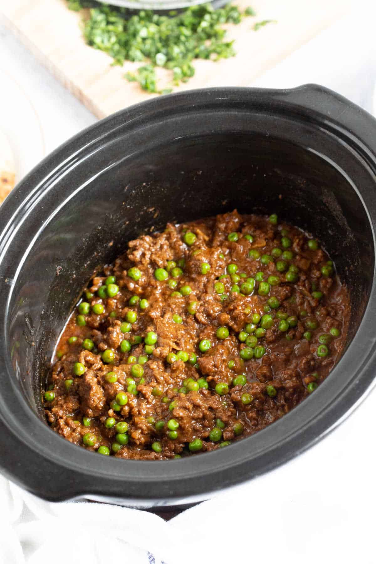 Slow cooker beef keema in a black slow cooker basin.