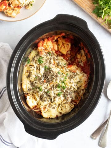 Slow cooker tortellini in black crock pot.