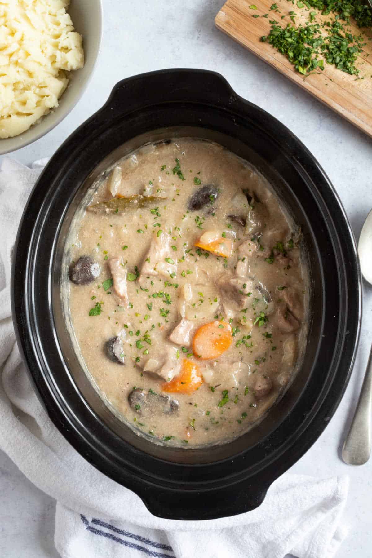 Pork and apple casserole in a slow cooker basin.