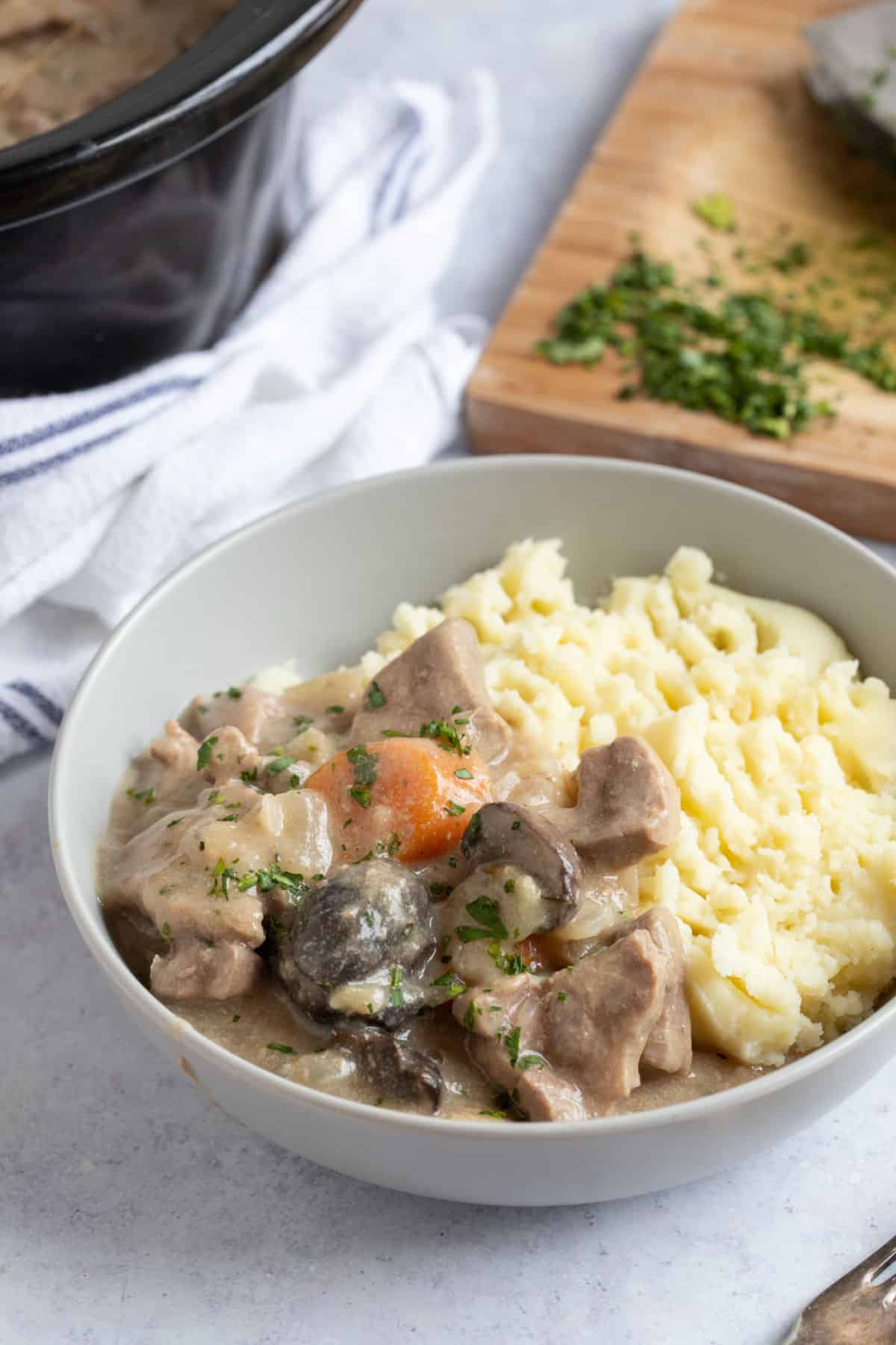 A bowl of creamy pork casserole with mash.