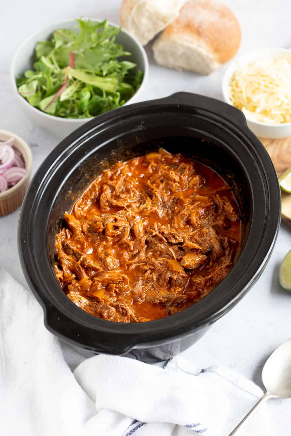 Slow cooker pulled beef in a slow cooker basin.