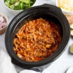 Slow cooker bbq pulled beef in a slow cooker basin.