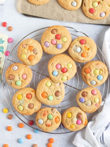 Smarties cookies on a wire cooling rack.