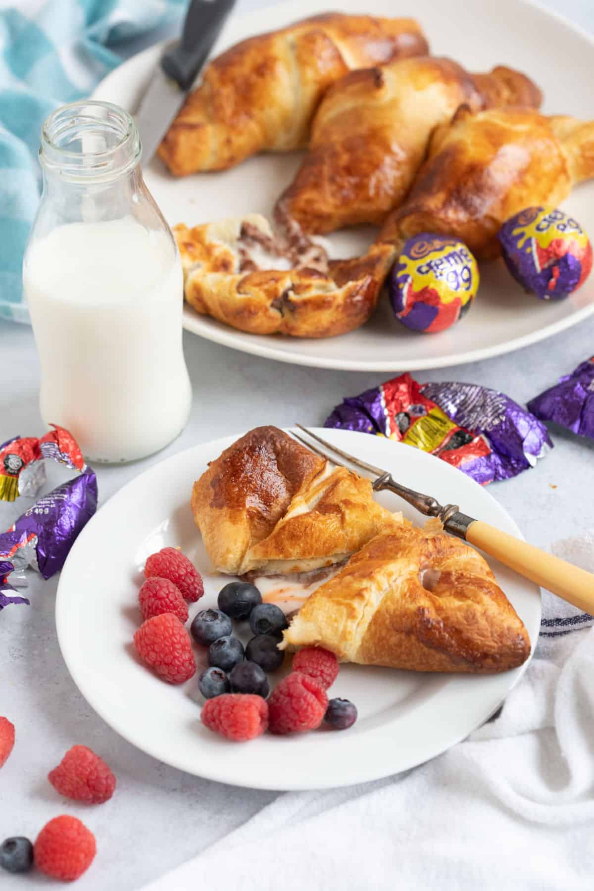 Air fryer creme egg croissant on a white plate with berries.