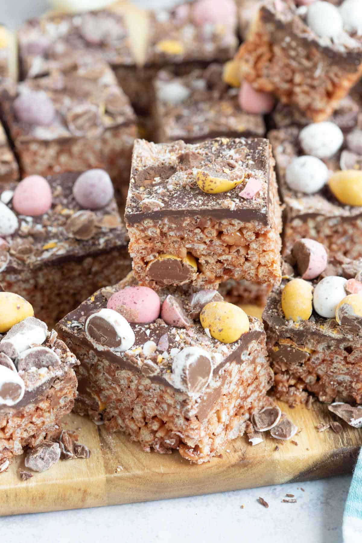 Mini egg rice krispie treats on a wooden board.